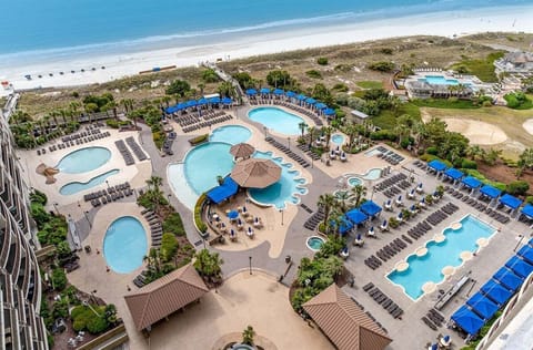 Enjoy the massive resort pool complex with multiple swimming areas, hot tubs, and swim-up bar.
