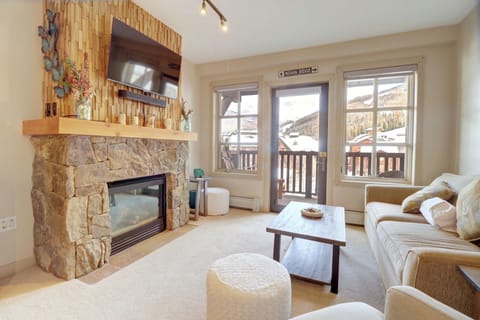Beautifully updated living area with patio, fireplace, and TV.
