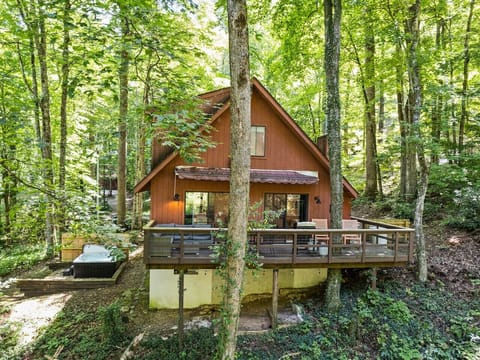 House set in wooded lot with deck overlooking stream