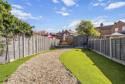 Long garden with a gravel path and green lawn on either side.