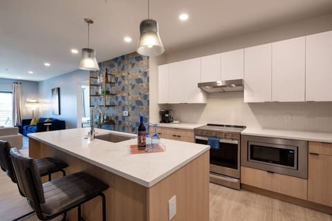 Modern and well-designed kitchen features an open layout with sleek cabinetry, stainless steel appliances, and a spacious central island, creating a functional and visually appealing cooking and entertaining space.