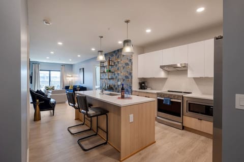 Modern and well-designed kitchen features an open layout with sleek cabinetry, stainless steel appliances, and a spacious central island, creating a functional and visually appealing cooking and entertaining space.
