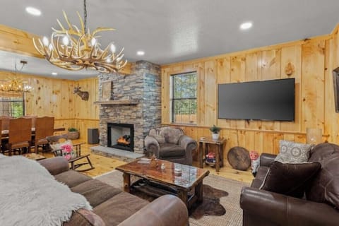 Open concept living and dining area with 65" Roku TV and family-style games