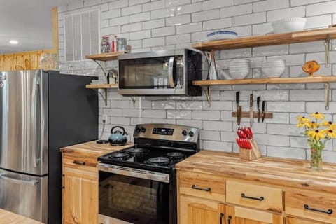 Full-sized refrigerator with bottom freezer, electric stove, and microwave