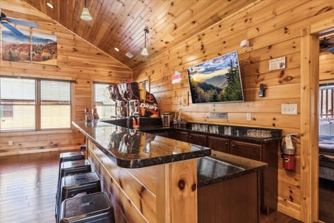 Equipped with an ice maker, bartender kit, shot glasses with shot board, whiskey glasses, mini fridge, and dishwasher, this space offers the ultimate sports bar experience.