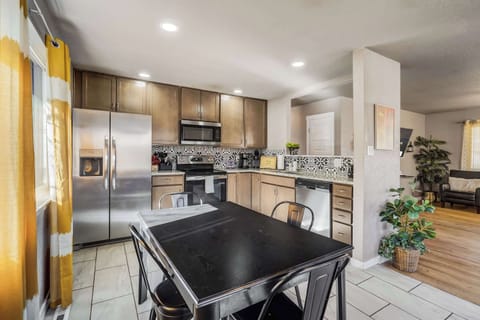 Cook with ease in the fully stocked kitchen, featuring modern appliances, ample counter space, and a stylish dining area perfect for enjoying meals together.