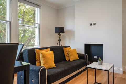 Living room in Fulham London rental with sofa bed, table & cozy space.