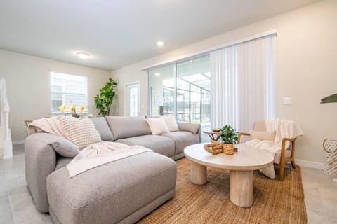 Spacious lounge with comfy sectional, natural light, and easy access to patio.