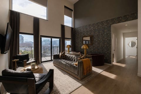 Stunning open-concept living space, tall ceiling and stylish patterned accent wall, and comfortable seating area.