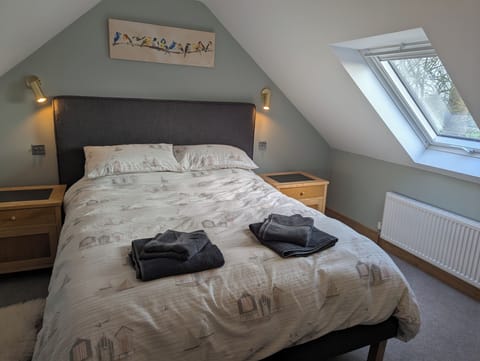 Comfortable king size bed with bedding and guest towels.  Feather duvet.
