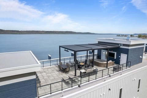 Shared rooftop area with TV, couches, firepit, and grill