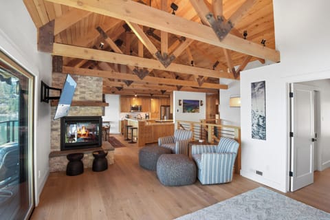 Open living space with lake view, TV, and fireplace