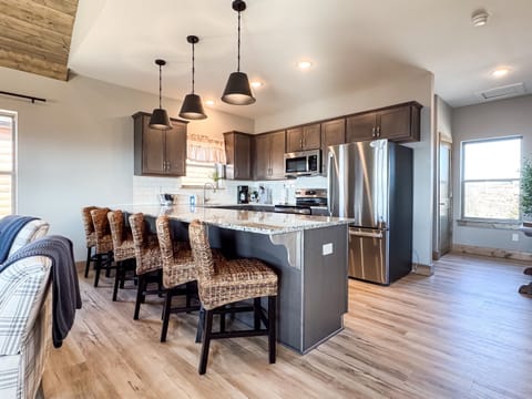 Fully equipped kitchen with seating at the island and double door fridge