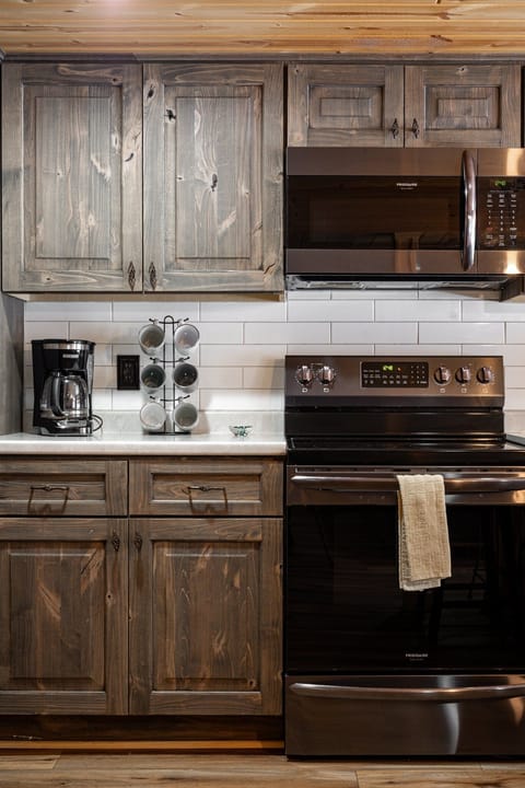 Fully equipped kitchen stocked with a drip coffee maker, coffee, cream, and sugar for your convenience