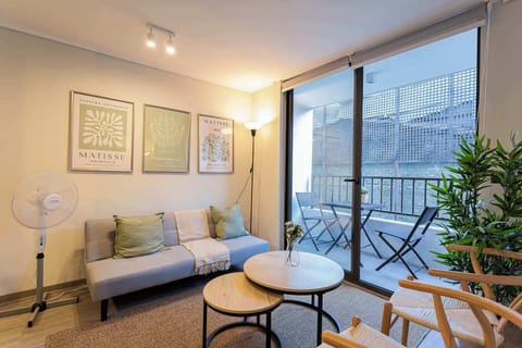 Relax in this cozy living room with stylish decor and a charming balcony view, perfect for unwinding after a day exploring the city.