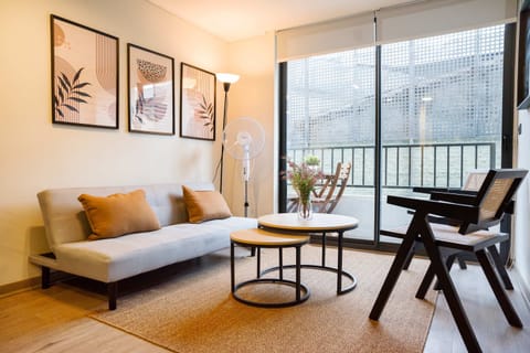 Relax in this stylish living area with a cozy sofa, modern decor, and a private balcony for a breath of fresh air.