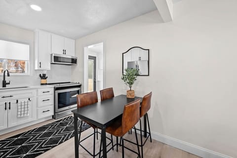 This elegant dining room connects beautifully with the modern kitchen, showcasing custom quartz countertops, modern appliances, and stunning cabinetry. Illuminated with natural light, this inviting space is perfect for cozy family dinners and stylish gath
