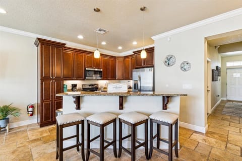 Morning coffee or evening wine? The granite kitchen island with bar stools is a sweet spot for both.