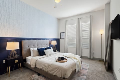 Unwind in this elegant queen bedroom, complete with a cozy bed, premium linens, and a serene atmosphere for a restful night's sleep.
