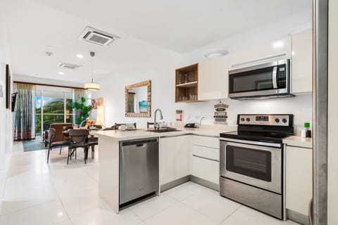 Cook with ease in this modern, fully equipped kitchen featuring stainless steel appliances - Open layout flows seamlessly into the dining & living area, perfect for gathering - Bright & functional, this space makes every meal feel like home