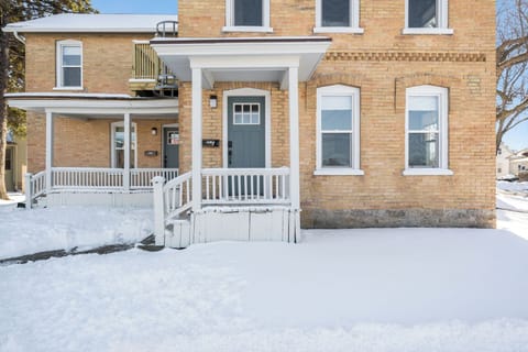 Welcome to this charming brick home, perfect for a winter getaway. The exterior boasts classic architecture with a welcoming front porch, covered for comfort. The snow-covered ground adds a picturesque touch, making it a cozy retreat in any season.