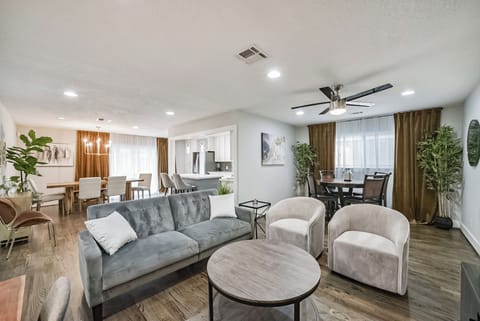 Unwind in the open-concept living room, featuring a sofa, smart TV, and a desk area. Ideal for gatherings, with board games and ample seating, creating a welcoming space for everyone to relax and connect.