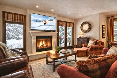 Stay cozy fireside in the spacious living room with plush seating, large Smart TV, and beautiful views.