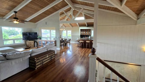 - Open concept design connects living room dining and kitchen   - Vaulted ceilings and hardwood floors enhance tropical feel   - Bright windows invite natural light throughout the space