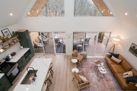 Bask in natural light and pond views from this stylish open-concept living area—featuring a fully equipped kitchen, cozy seating, and direct access to the outdoor deck.