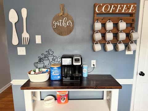 Coffee bar stocked with grounds, k cups, creamers, and sugar