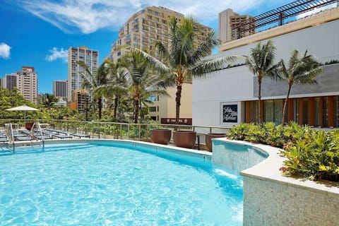 Dive into a sunlit pool framed by swaying palms.