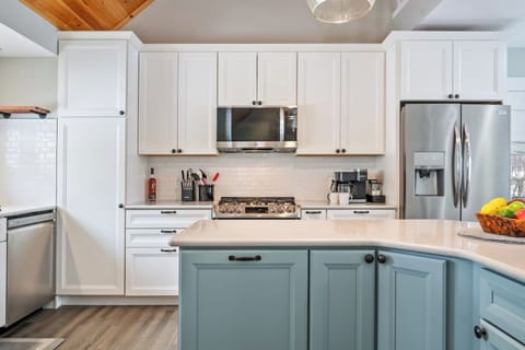 Welcome to this inviting and modern kitchen, where contemporary elegance blends with cozy cabin charm! Featuring sleek stainless steel appliances, crisp white cabinetry, and a warm wood-paneled ceiling, this space is perfect for cooking up a feast or