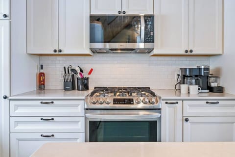 Cook in Style! This modern kitchen is designed for food lovers, featuring a gas range, sleek stainless steel appliances, and a classic subway tile backsplash.