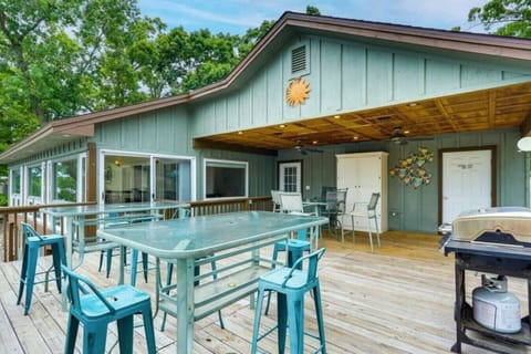 Large outdoor deck with ample seating and dining space, complete with a grill, perfect for al fresco dining and lakefront gatherings.