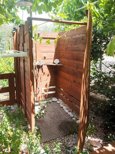 Outdoor shower, surrounded by lush greenery, for unwind moments 