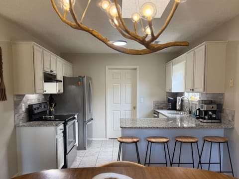 DINE: Enjoy a home-cooked meal in the open dining space, perfect for reconnecting. The compact kitchen is stocked with all your cooking essentials. 