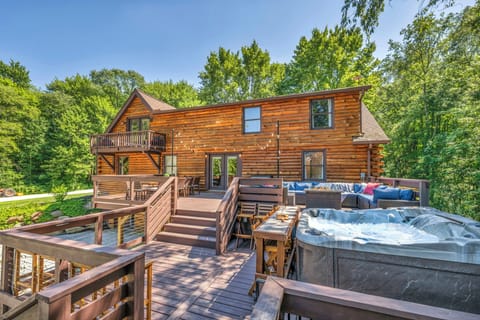 The spacious back deck, huge sectional sofa, outdoor dining, bar seating, and lots of flexible seating by the bubbling hot tub under the string lights.