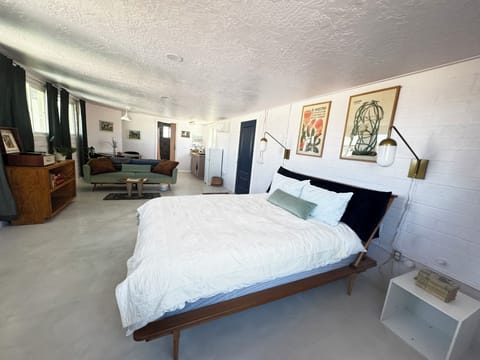 Cozy queen bed with crisp cotton or linen bedding.