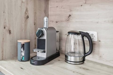 Kaffeemaschine mit Kapselbehälter und moderner Wasserkocher für zusätzlichen Komfort.