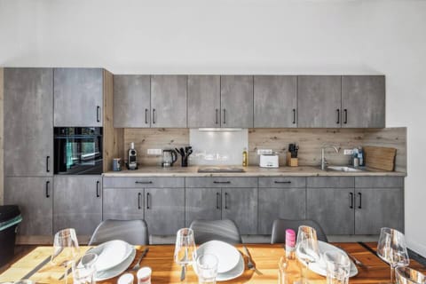 Moderne Einbauküche mit grauen Fronten, viel Stauraum und kompletter Ausstattung für entspanntes Kochen.