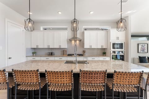 Leather barstools, stainless steel appliances, and modern design.