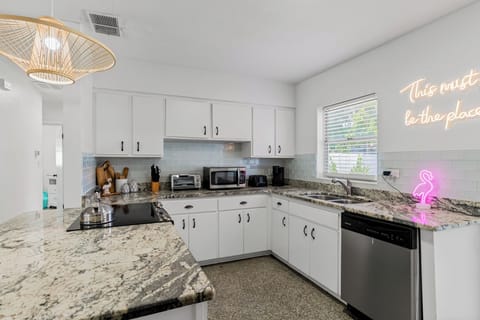 A modern kitchen with granite countertops and stainless-steel appliances, perfect for home-cooked meals.