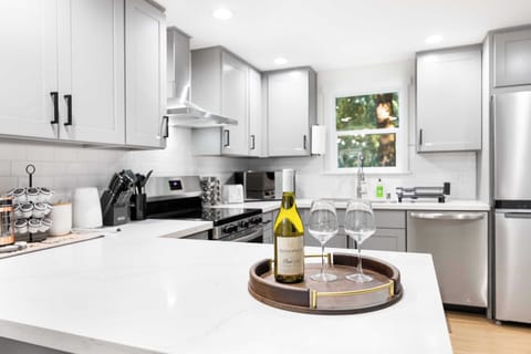 Indulge in a welcoming touch with a bottle of wine and glasses waiting on the spacious kitchen island. This open and airy kitchen invites you to relax, whether you’re cooking or sharing a drink with friends while enjoying the view.