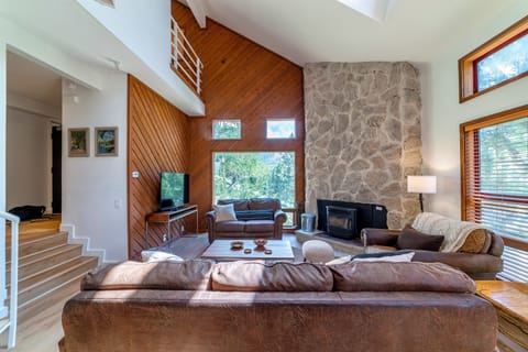 Bright living room with large picture windows overlooking the gorgeous mountain/forest scenery.