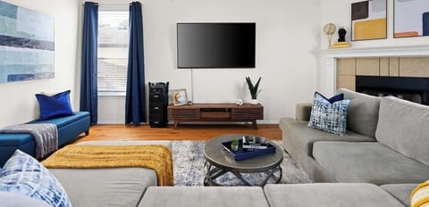 Inviting living room with a plush sectional, smart TV, and stylish décor. Conveniently located near Dell Diamond, Kalahari, and Round Rock Donuts—ideal for relaxing!