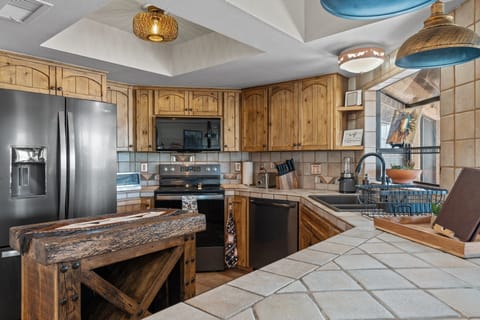 Modern and efficient—everything you need to create a delicious meal. The kitchen features a stainless steel refrigerator, stove, coffee maker, kitchenette oven, kettle, and blender.