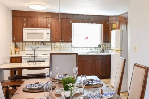 Warm and inviting kitchen with charm, a fully stocked setup, and a dining table perfect for shared meals and gatherings.