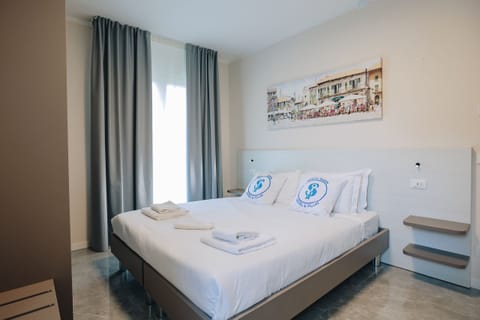 Elegant double room located within an apartment with garden in the modern Ranalli Palace residence in Peschiera del Garda. Furnished in a contemporary style with relaxing colors, it offers a bright and comfortable environment, ideal for couples or business trips. Guests can enjoy the private garden and the strategic location just a few steps from the Pederzoli Hospital and the historic center of Peschiera.