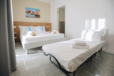 Modern and bright triple room located in the Ranalli Palace residence in Peschiera del Garda, a short walk from the Pederzoli Hospital. Equipped with a comfortable double bed and an additional single bed, it is the ideal solution for families or small groups. Elegant furnishings, marble floors, and a private bathroom complete the welcoming and functional environment.