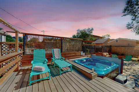 Private hot tub & deck with lounge chairs & bar top.